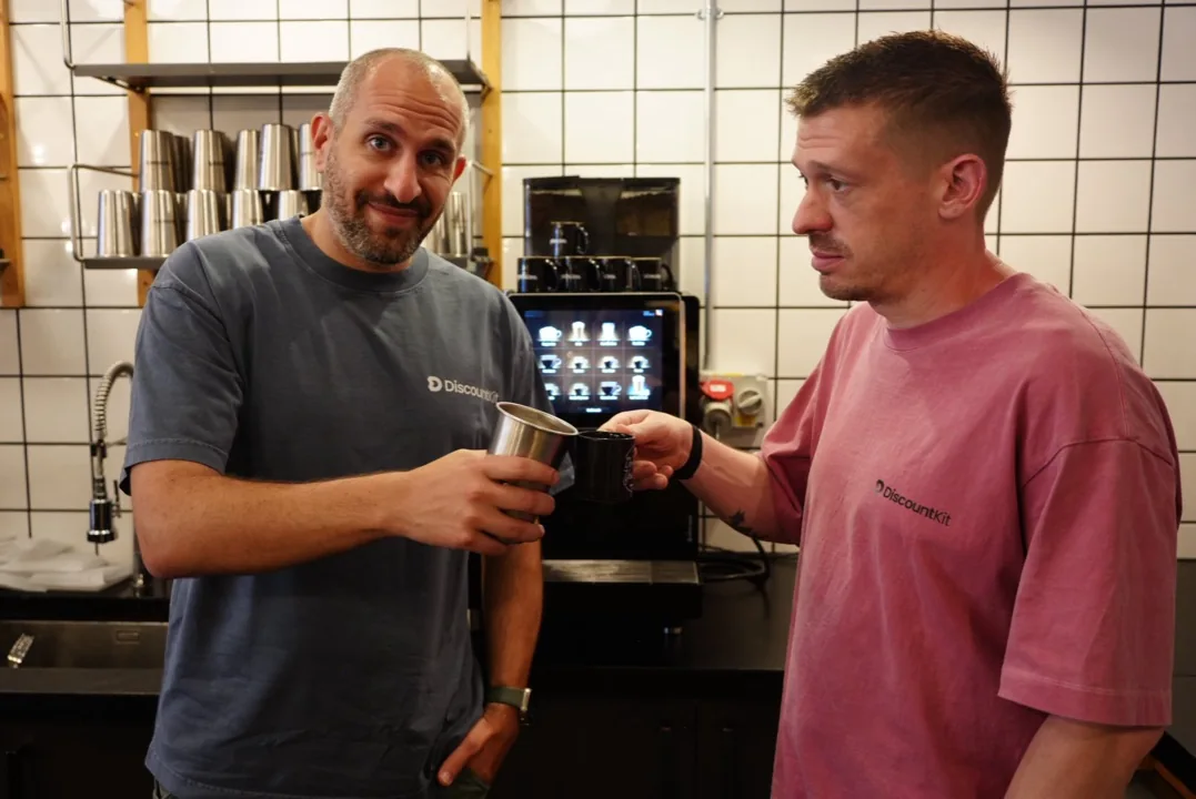 Sammy and Dave toasting mugs at the office coffee machine