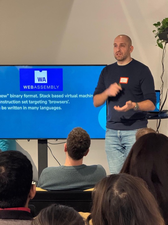 Sammy on stage giving a talk about WebAssembly